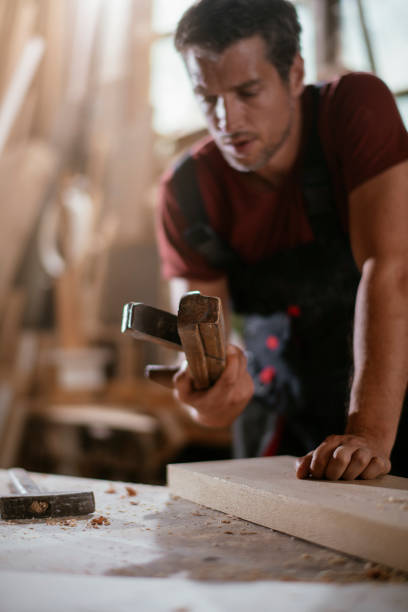 Carpenter at work stock photo. Shadow DOF. Developed from RAW; retouched with special care and attention; Small amount of grain added for best final impression. 16 bit Adobe RGB color profile.