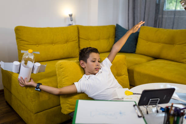 istock Boy playing with an airplane made from recycled paper and plastic 1165703365
