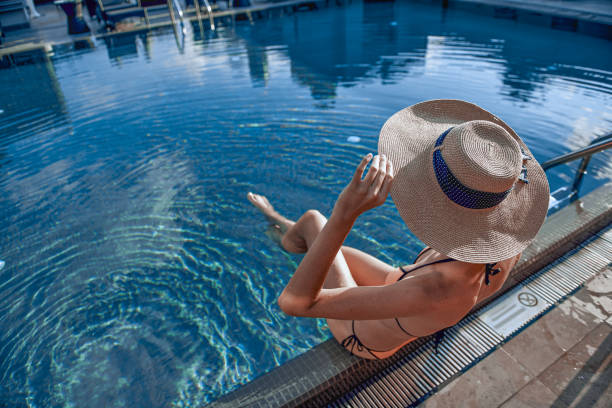 istock Young lady with nice sunhat looking at the reflection on water 1165705649