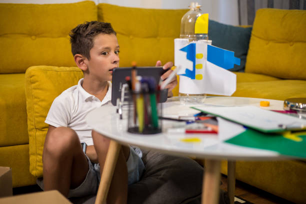 istock Boy is stunned with his DIY airplane toy made from plastic and paper 1165705856