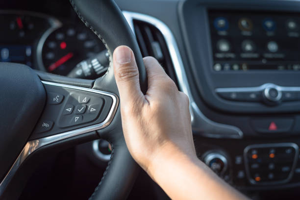 istock Asian man hand holding steering wheel with audio control and call buttons 1165705985