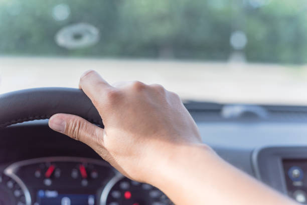 istock Close-up Asian man hand holding modern car steering wheel 1165706048