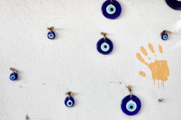 dekorative böse auge perlen hängen an einer weißen wand - evil eye beads stock-fotos und bilder