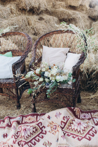istock Wedding asymmetrical stylish bouquet with roses on a boho wicker chair. 1165710320