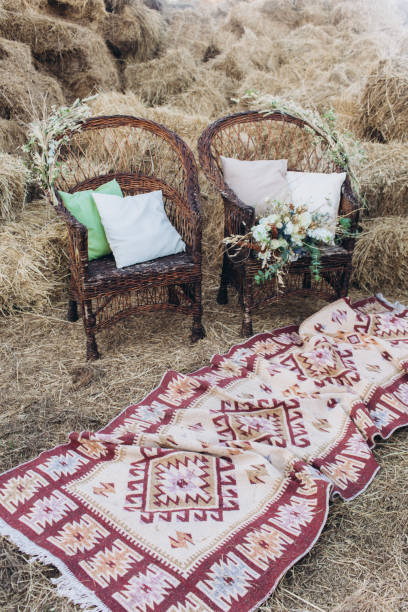 istock Wedding asymmetrical stylish bouquet with roses on a boho wicker chair. 1165710404