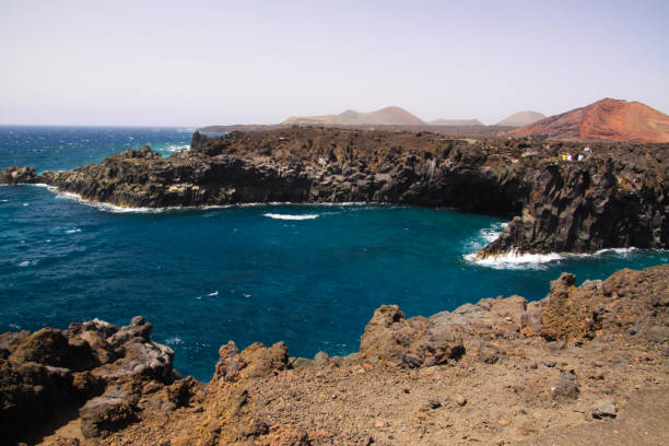 istock View on rugged rough coastline with sharp cliffs. lagoon with turquoise blue water, waves 1165710408