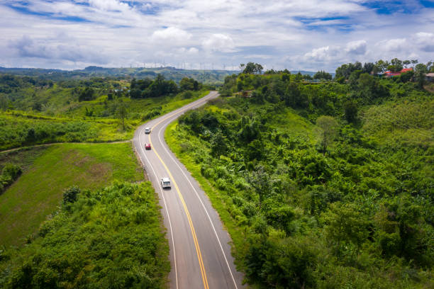 istock Aerial view over mountain road going through tropical rainforest landscape in Thailand. 1165710565