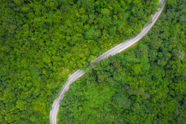 istock Aerial view over mountain road going through tropical rainforest landscape in Thailand. 1165710567