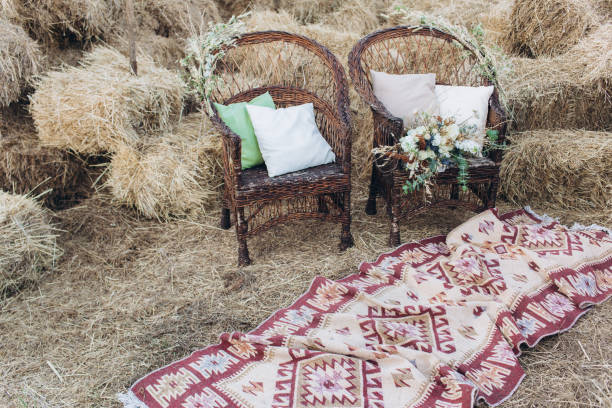 istock Wedding asymmetrical stylish bouquet with roses on a boho wicker chair. 1165710585