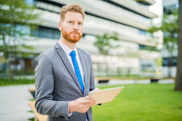istock Handsome young businessman using a digital tablet outdoors. 1165712091