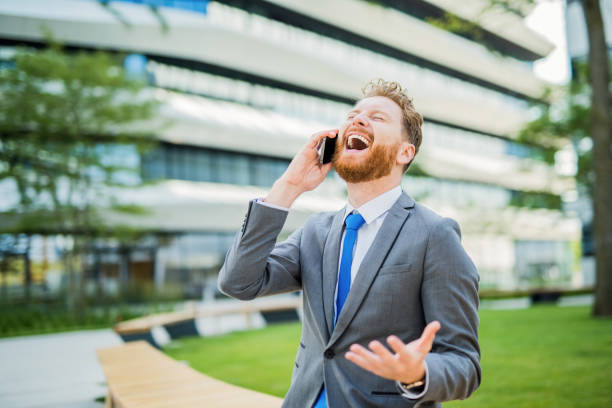 istock Happy young businessman talking on the phone outdoors and laughing. 1165712106