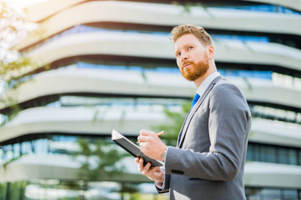 istock Young businessman taking notes outdoors. 1165712175