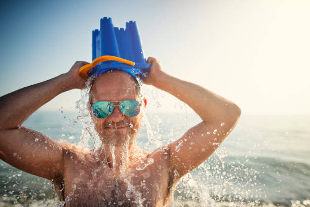hombre enfriándose con cubo de agua - spraying beaches summer sunlight fotografías e imágenes de stock
