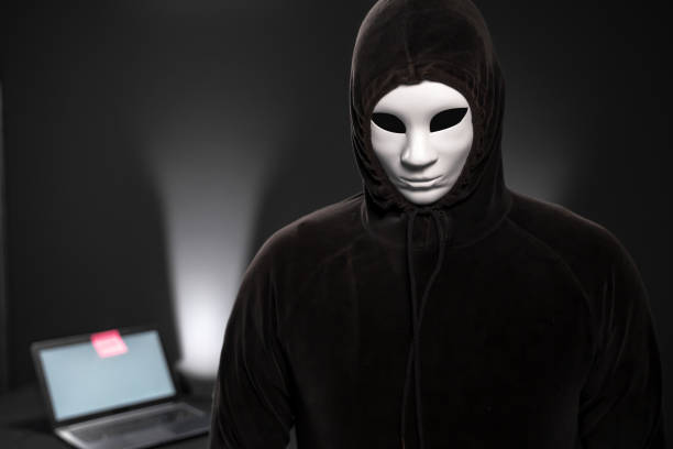 istock Hacker  looking  at the camera in front of a desk with laptop 1165713416