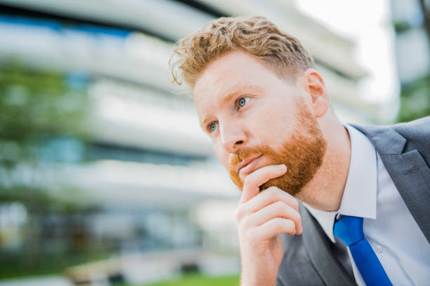 istock Handsome young businessman leaning on his hand and thinking. 1165713423