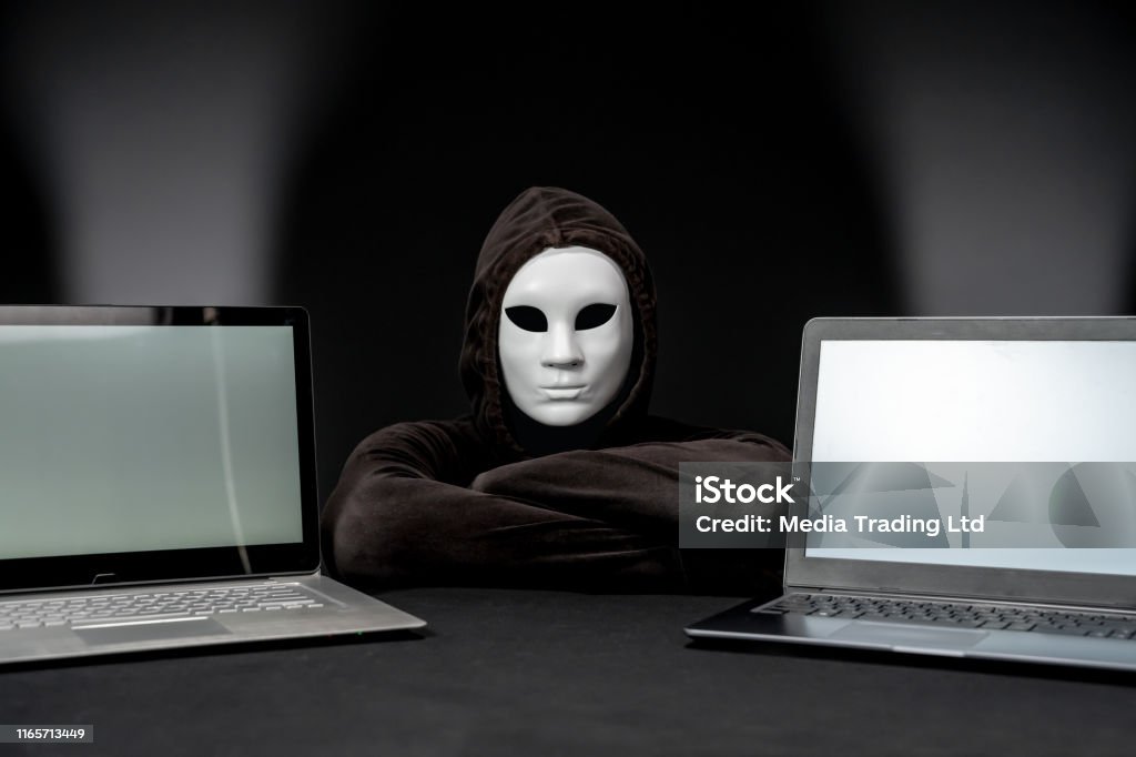 Hacker One Computer Screen Hooded Computer Hacker Between Two Laptop Screens Stock Photo ...
