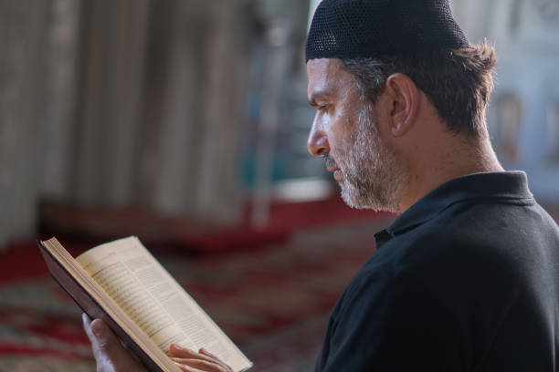 istock Muslim man reading koran in mosque 1165715060