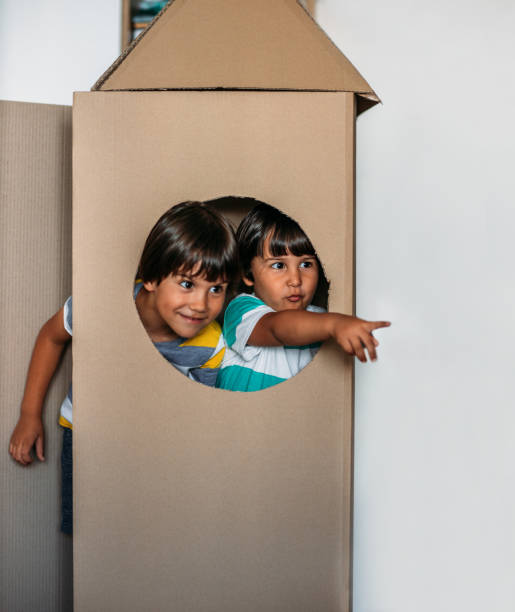 istock Adorable Little Boys Playing With Cardboard Rocket At Home 1165715868