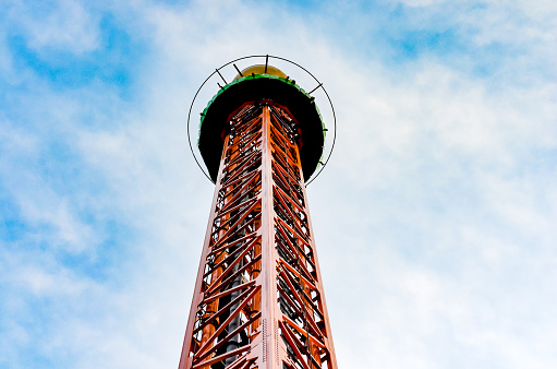 Close-up   view of vertical  iron drop tower or big drop in a amusement  park against  blue sky .