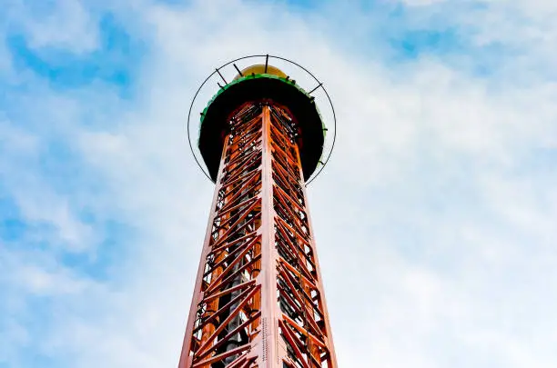 Close-up   view of vertical  iron drop tower or big drop in a amusement  park against  blue sky .