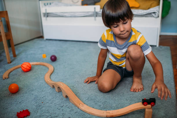 istock Cute Little Boy Playing With Wooden Toy Train 1165716473