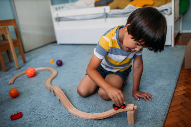 istock Cute Little Boy Playing With Wooden Toy Train 1165716474