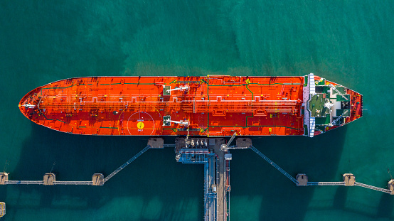 Aerial view tanker ship unloading at port, Business import export oil with tanker ship transportation oil from refinery on the sea.
