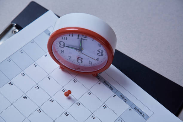 istock Time management, deadline and schedule concept: alarm clock and pushpin on schedule plan 1165721506