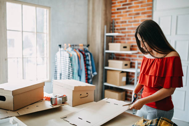 istock Young woman packing goods for shipment 1165722157