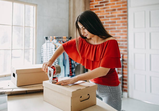 istock Young woman packing goods for shipment 1165722254