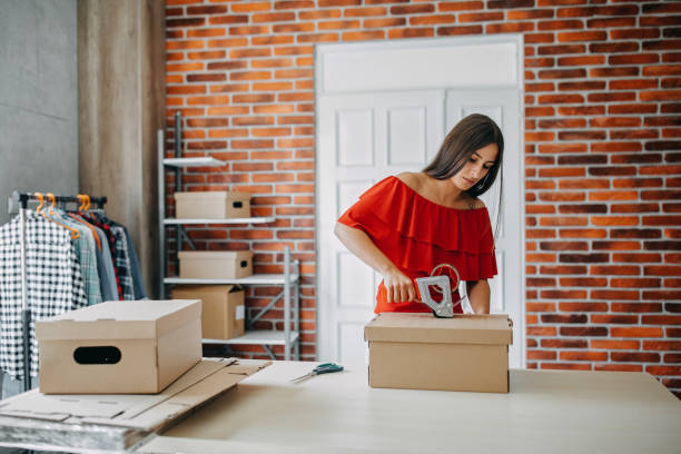 istock Young woman packing goods for shipment 1165722851