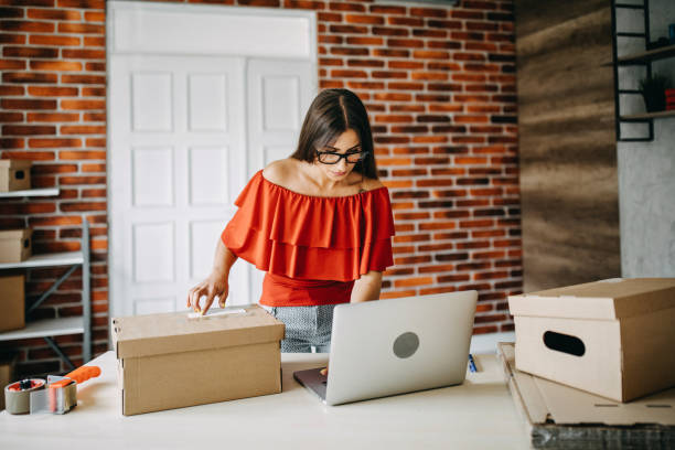 istock Young woman packing goods for shipment 1165722877