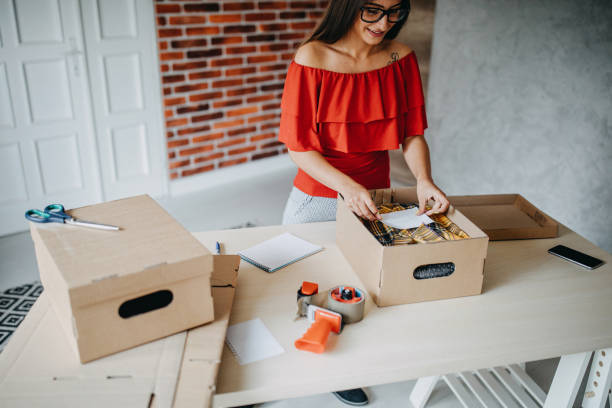 istock Young woman packing goods for shipment 1165722952