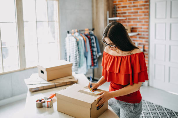 istock Young woman packing goods for shipment 1165723088