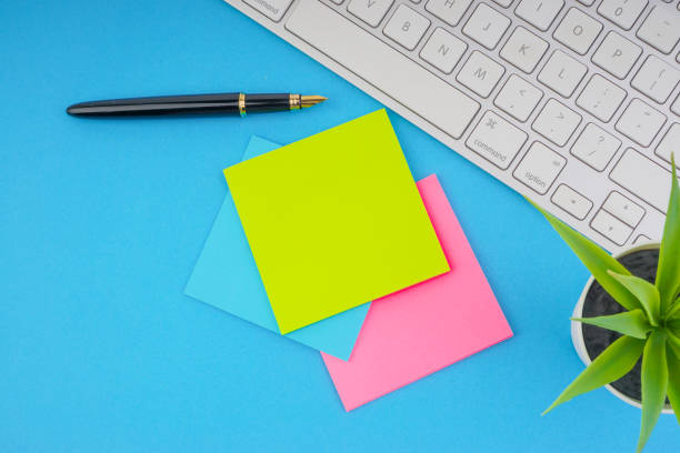 istock Workspace with pen, sticky notes, decoration vase and keyboard on the blue background. 1165727632