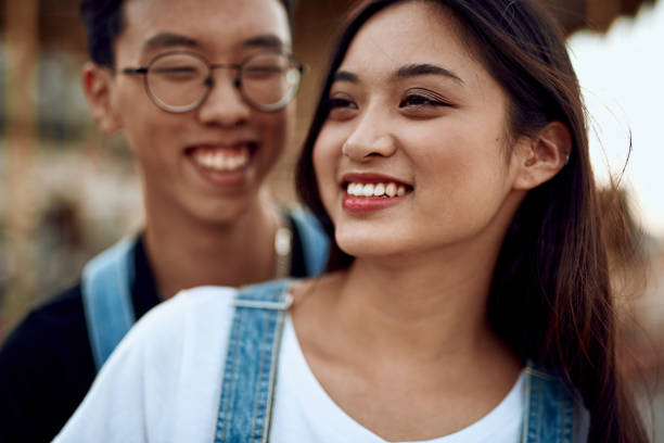 istock Happy asian lady and guy staying together 1165729268