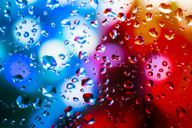 istock Neon lights behind water drops close up 1165729742
