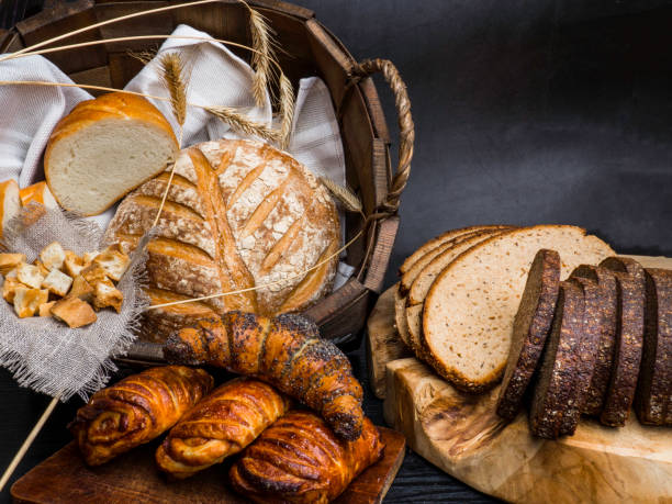 istock Different kinds of fresh bread on wooden table. Seletive focus, Space for text 1165731539