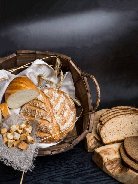 istock Different kinds of fresh bread on wooden table. Seletive focus, Space for text 1165731660