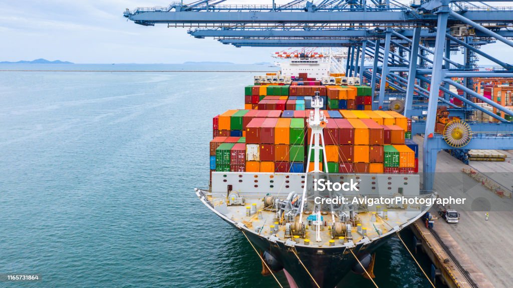 Cargo ship terminal, Unloading crane of cargo ship terminal, Industrial port with containers and container ship. Freight Transportation Stock Photo