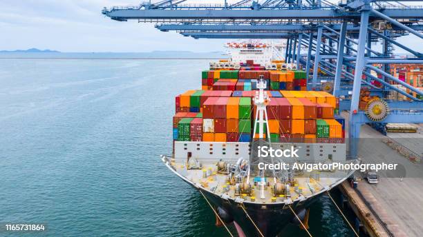 Cargo Ship Terminal Unloading Crane Of Cargo Ship Terminal Industrial Port With Containers And Container Ship Stock Photo - Download Image Now