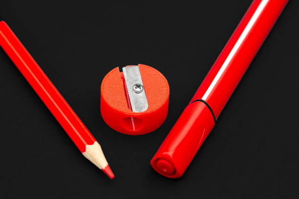 istock Red pencil, marker and pencil sharpener on black background 1165733695