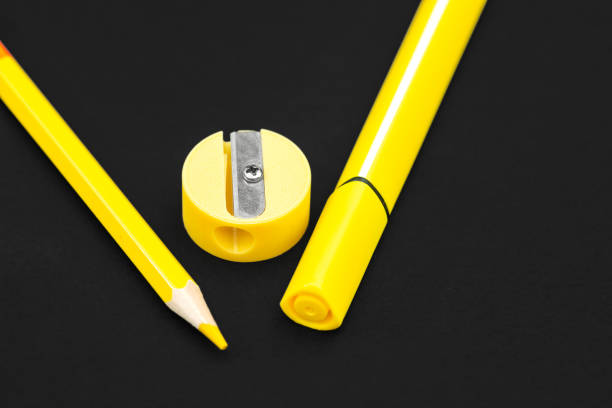 istock Yellow pencil, marker and pencil sharpener on black background 1165733764