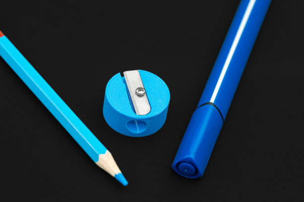 istock Blue pencil, marker and pencil sharpener on black background 1165733769