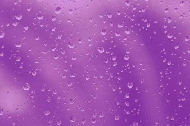 istock Rain drops on window glass purple toned blurred background 1165733945
