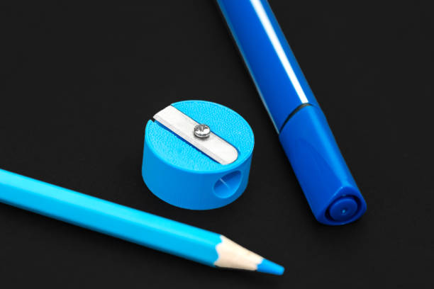 istock Blue pencil, marker and pencil sharpener on black background 1165733988
