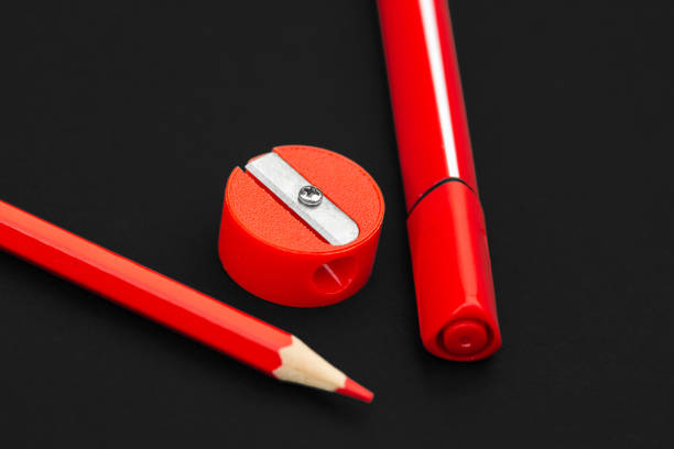 istock Red pencil, marker and pencil sharpener on black background 1165734019