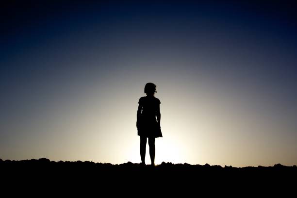 istock Silhouette of a girl standing on a hill 1165734861