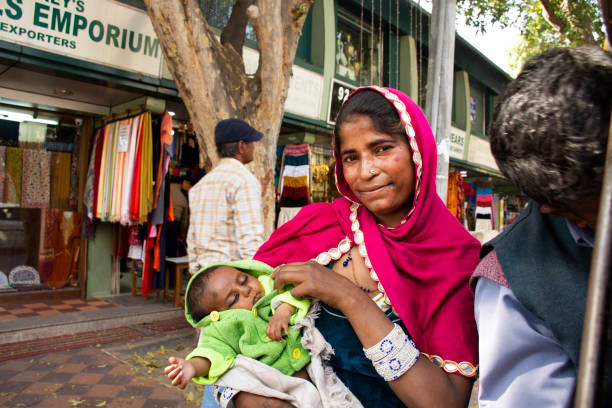 mulheres indianas mendigo ou intocáveis casta segurar o bebê e implorando dinheiro - india slum poverty family - fotografias e filmes do acervo