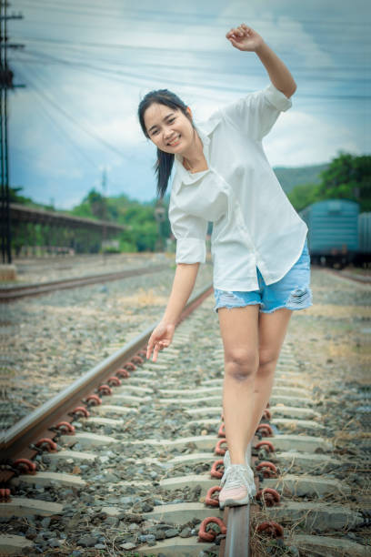 istock Women are walking on the train tracks with fun. 1165737062